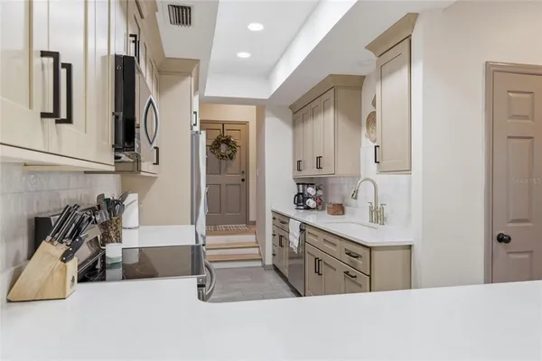 a kitchen with stainless steel appliances a sink and cabinets