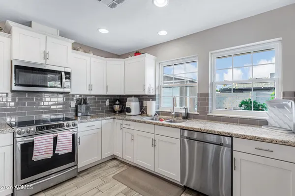 a kitchen with stainless steel appliances granite countertop a sink a stove and cabinets