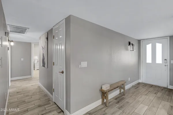 a view of a hallway with wooden floor and a bathroom