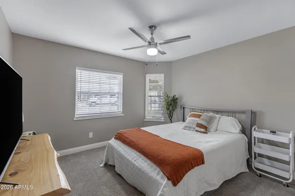 a bedroom with a bed and a flat tv screen on the dresser