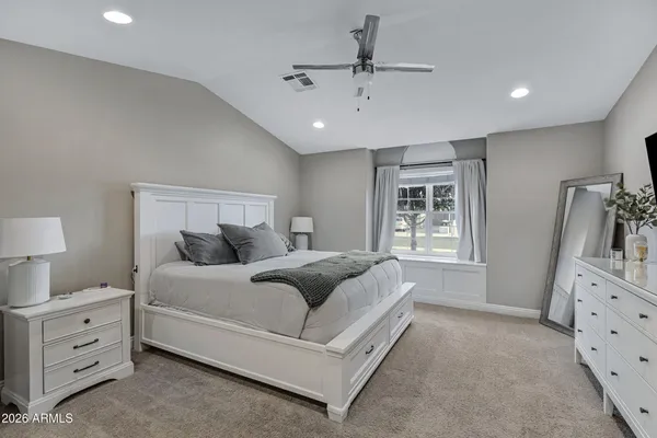 a spacious bedroom with a bed and a dresser