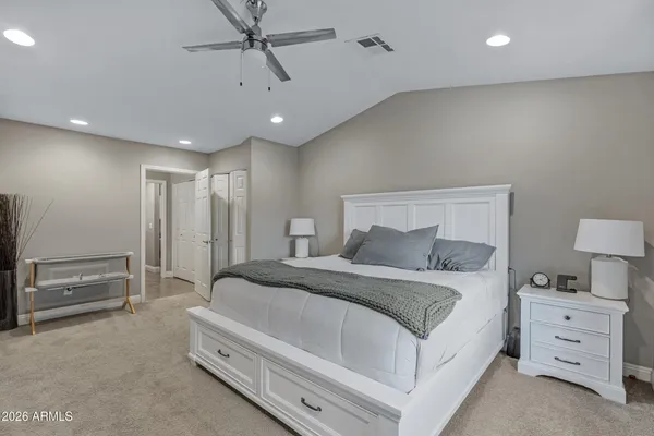 a spacious bedroom with a bed and a cabinets