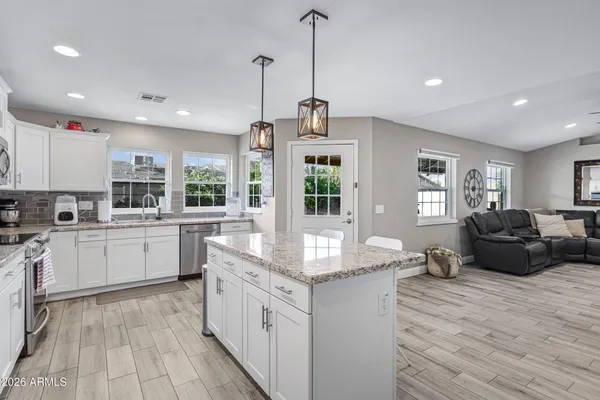 a kitchen with stainless steel appliances granite countertop a sink counter space cabinets and a large window