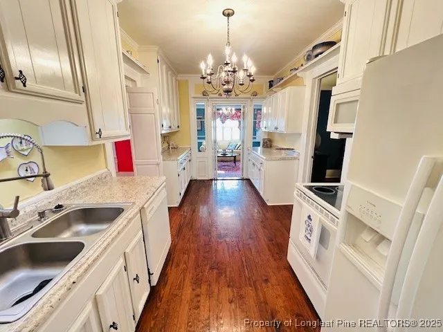 a kitchen that has a lot of cabinets and wooden floor