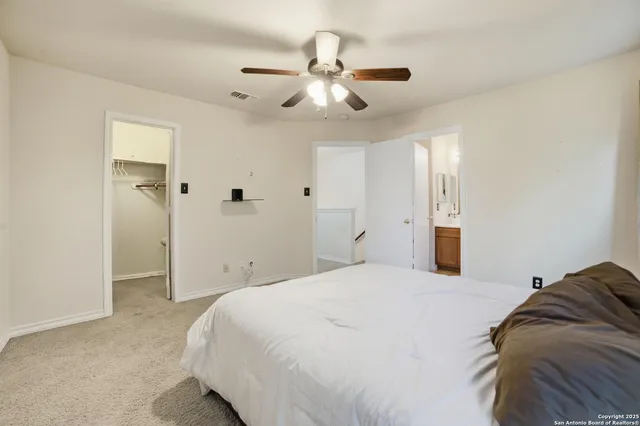a spacious bedroom with a bed and a chandelier
