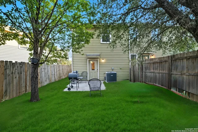 a view of a backyard with table and chairs and wooden fence
