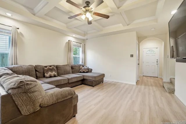 a living room with furniture and a ceiling fan