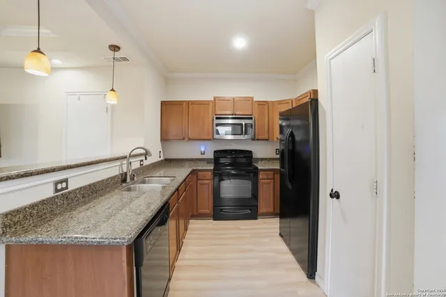 a kitchen with stainless steel appliances granite countertop a sink stove and refrigerator