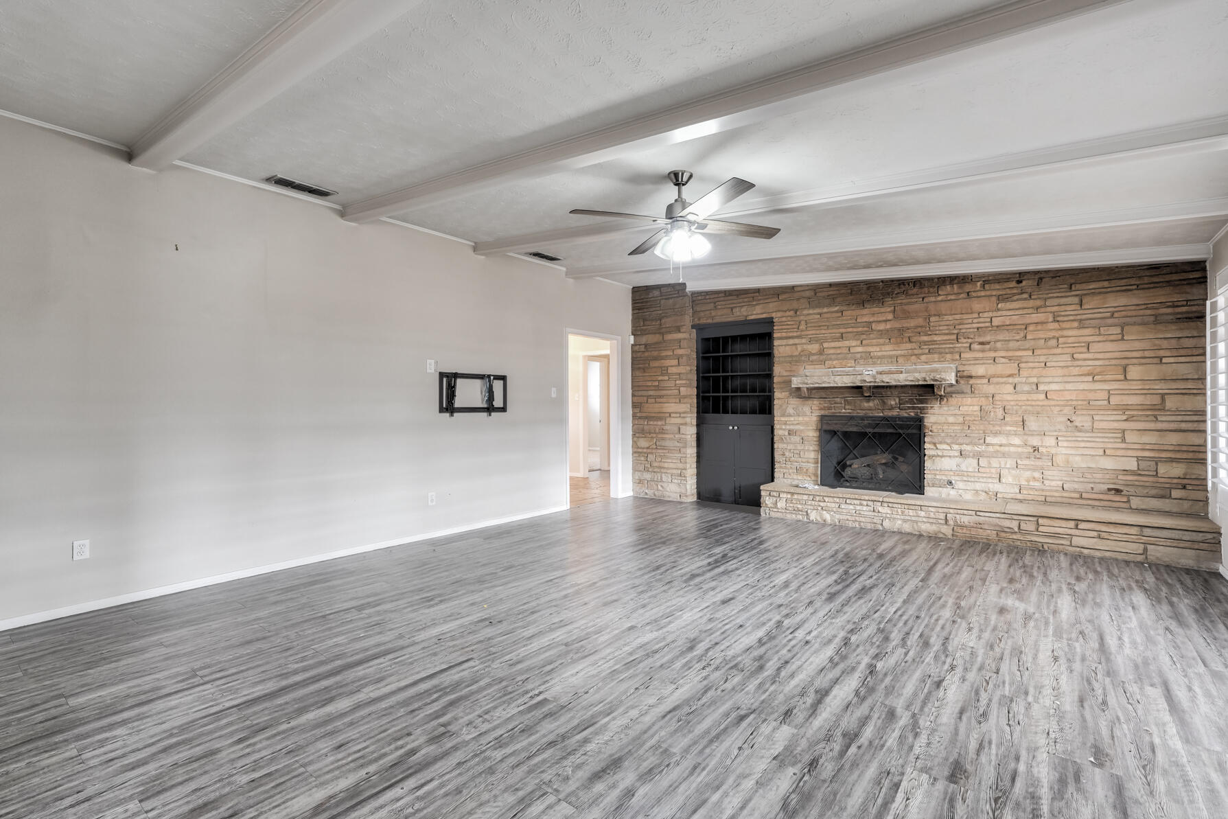 3303 53rd Street Lubbock, TX 79413 - Photo 25 of 72 a view of empty room with wooden floor and fireplace