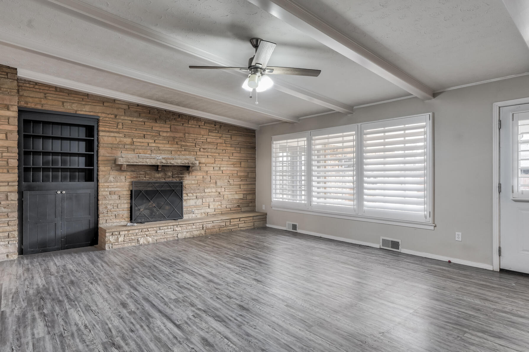 3303 53rd Street Lubbock, TX 79413 - Photo 27 of 72 a view of an empty room with wooden floor fireplace and a window