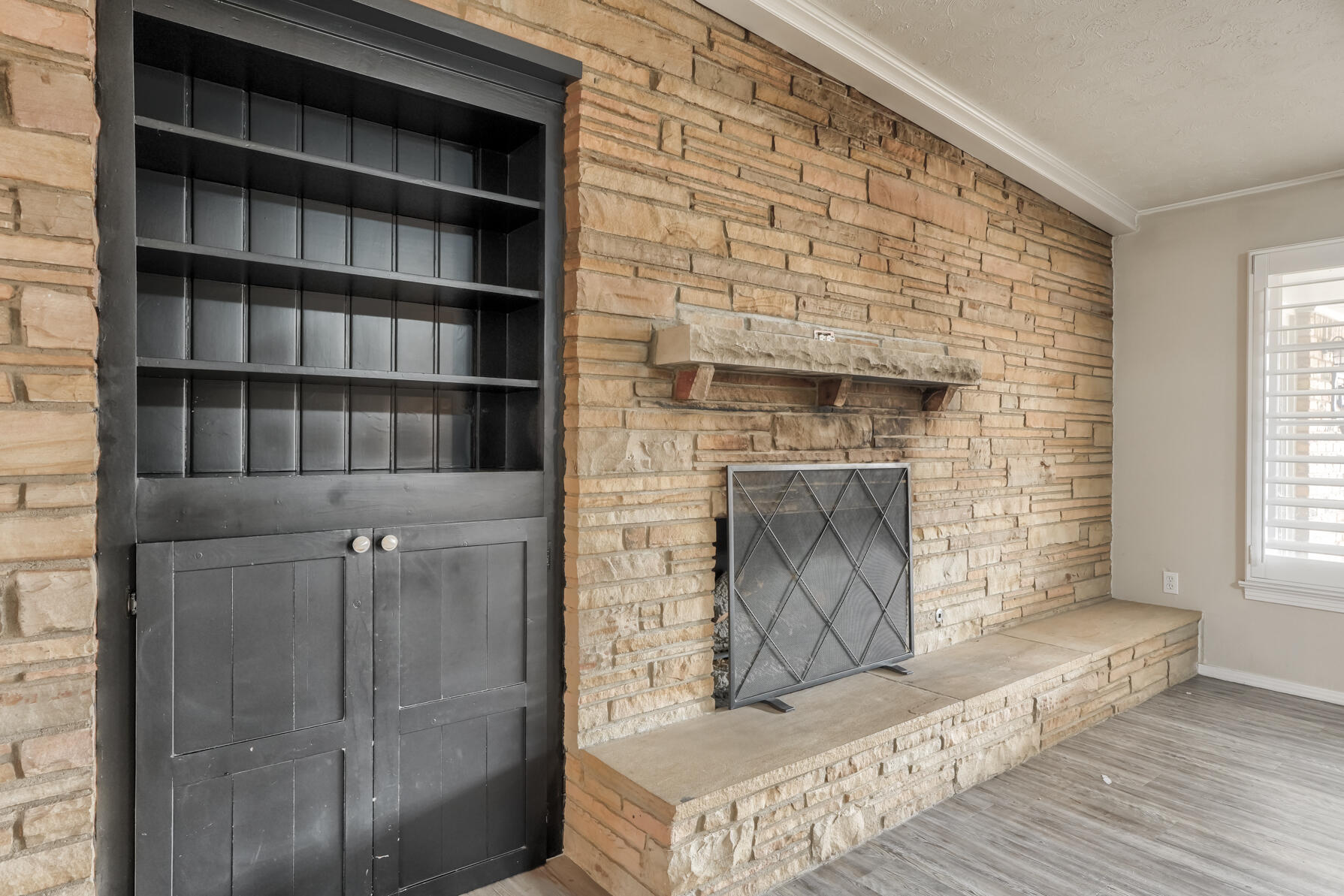 3303 53rd Street Lubbock, TX 79413 - Photo 29 of 72 a living room with a fireplace and a book shelf