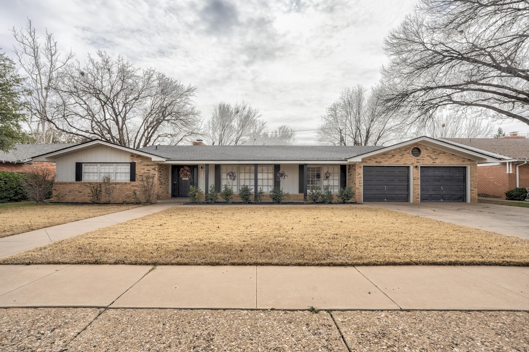 3303 53rd Street Lubbock, TX 79413 - Photo 4 of 72 a front view of a house with a yard and wooden fence