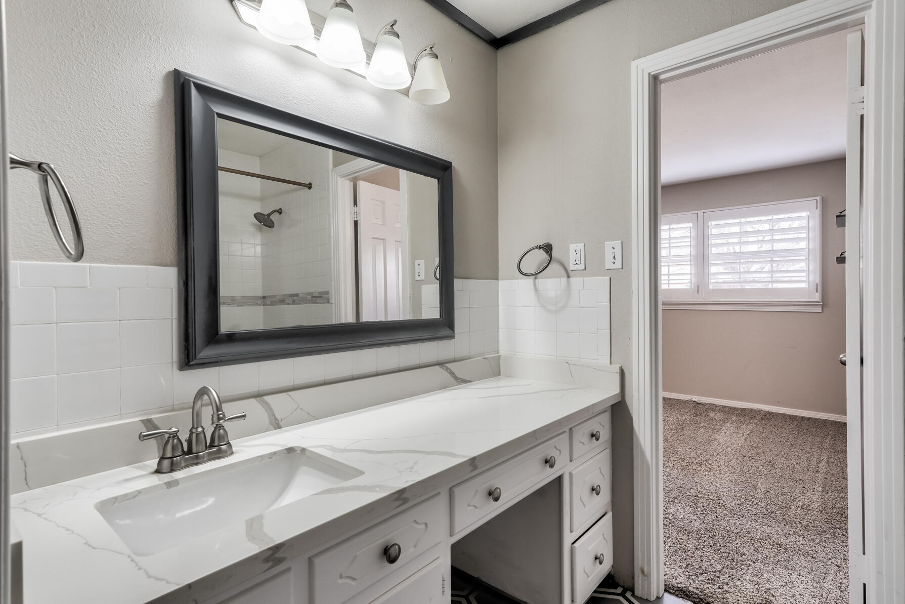 3303 53rd Street Lubbock, TX 79413 - Photo 50 of 72 a bathroom with a sink vanity and a mirror