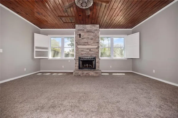 wooden floor fireplace and windows in an empty room