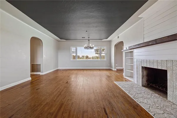 a kitchen with a wooden floor and white cabinets with wooden floor