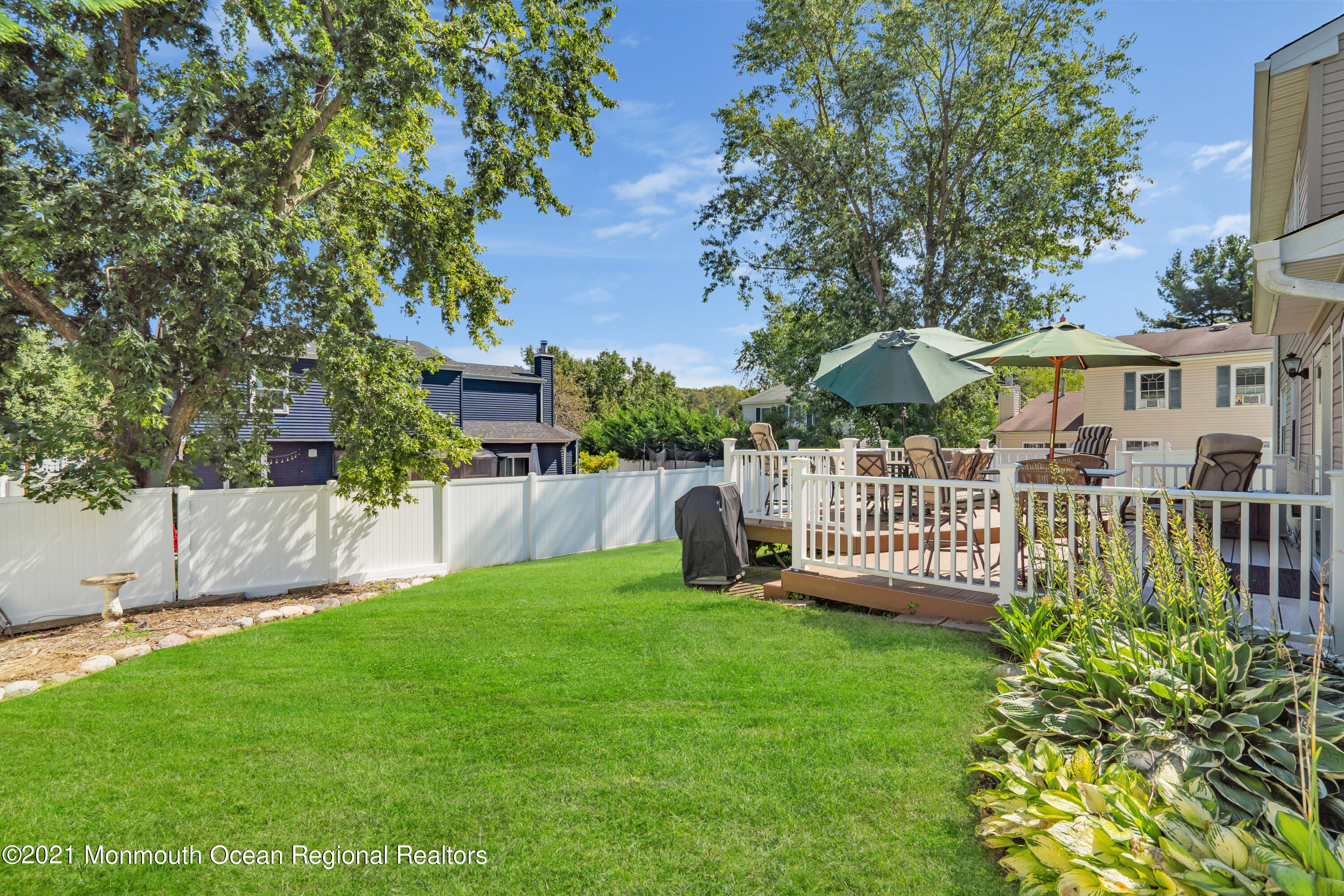 181 Friendship Road Howell, NJ 07731 - Photo 31 of 36 a view of a deck with a table and chair under an umbrella