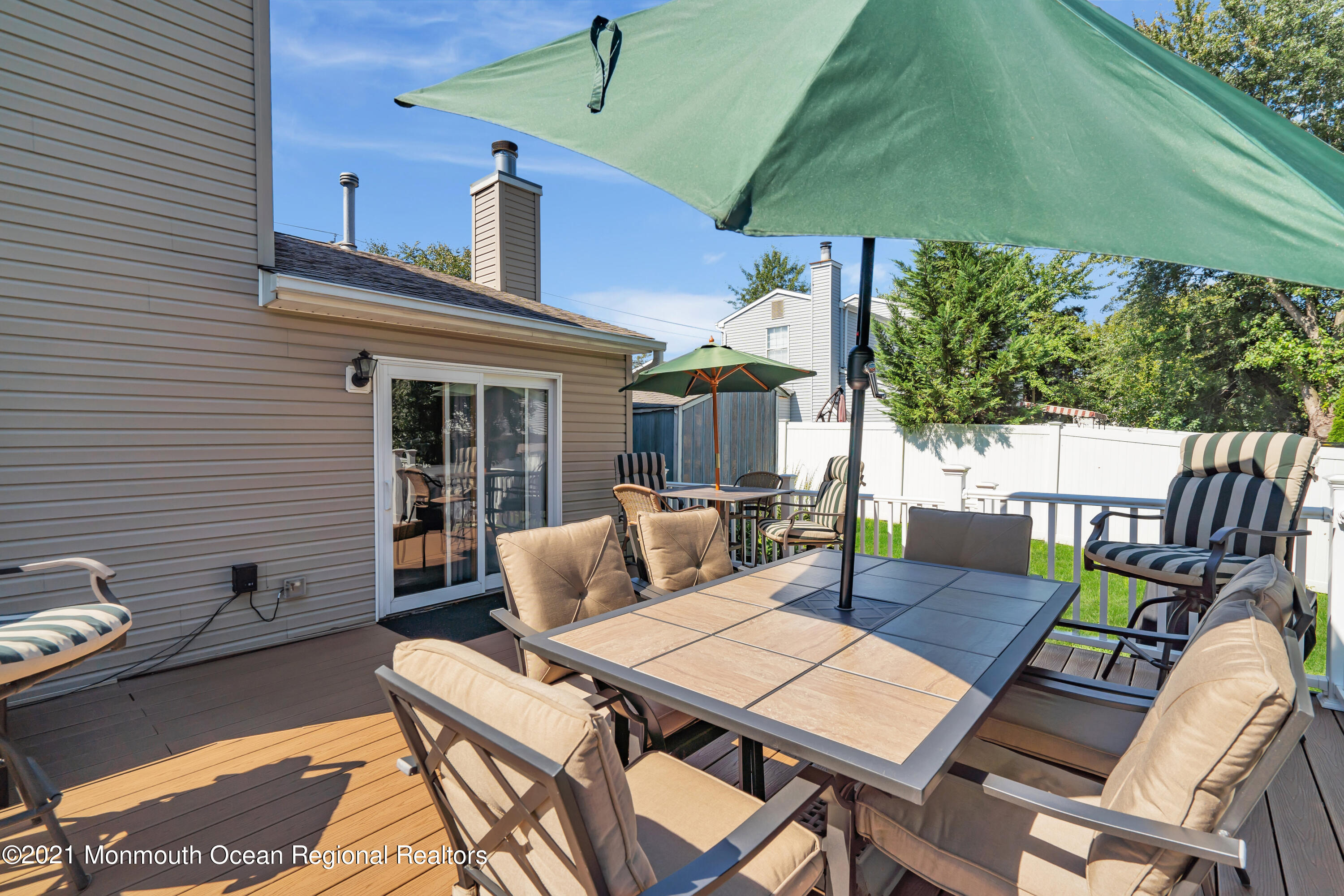 181 Friendship Road Howell, NJ 07731 - Photo 34 of 36 a view of a patio with a dining table and chairs under an umbrella