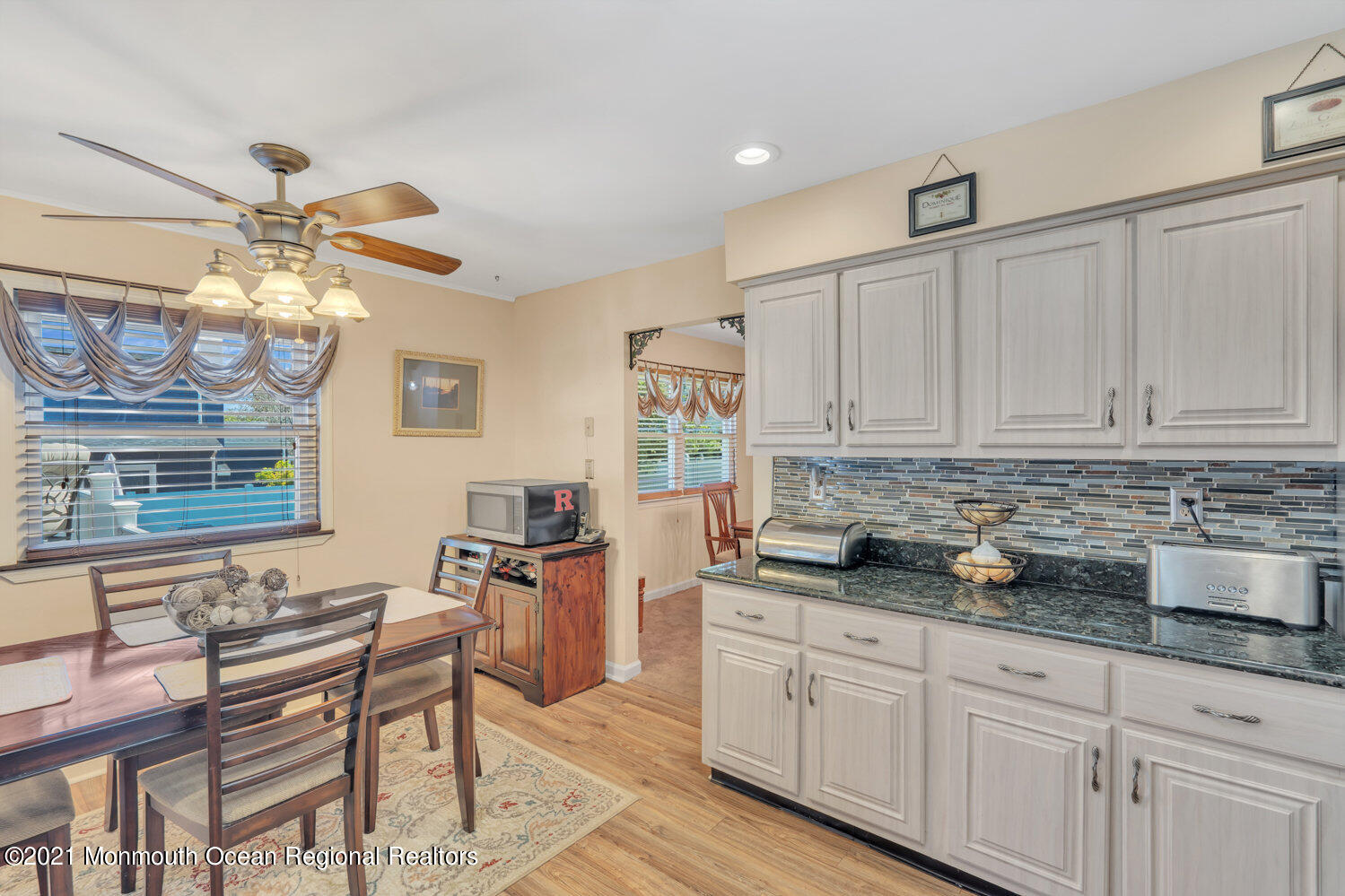 181 Friendship Road Howell, NJ 07731 - Photo 6 of 36 a kitchen with stainless steel appliances granite countertop a stove a sink dishwasher a dining table and chairs with wooden floor