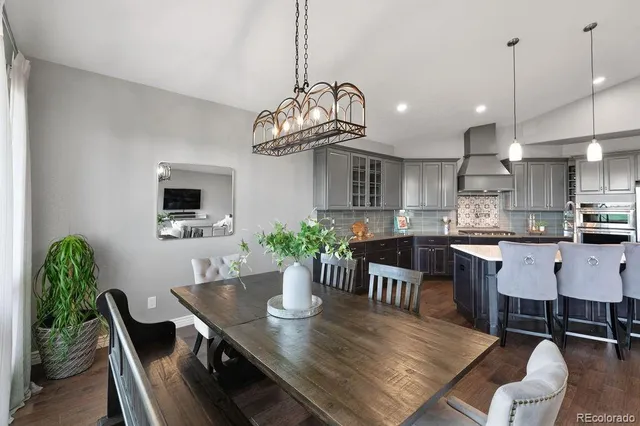 a dining room filled chandelier and kitchen view