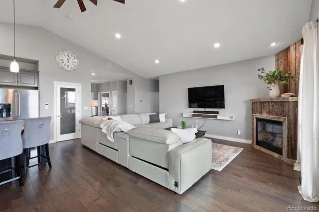a living room with furniture a flat screen tv and a fireplace