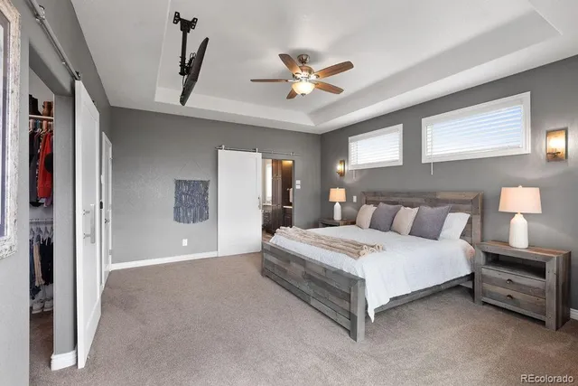 a spacious bedroom with a large bed and a chandelier