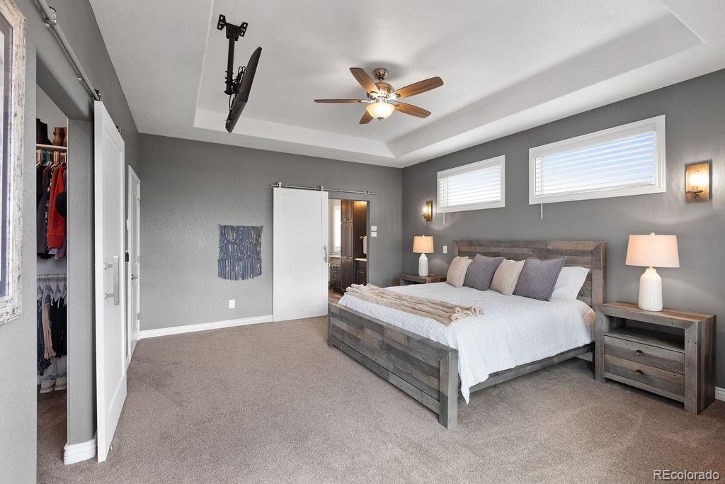 3050 Native Court Wellington, CO 80549 - Photo 24 of 50 a spacious bedroom with a large bed and a chandelier