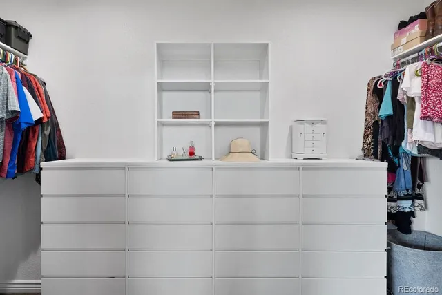 a view of walk in closet with clothes and shoes