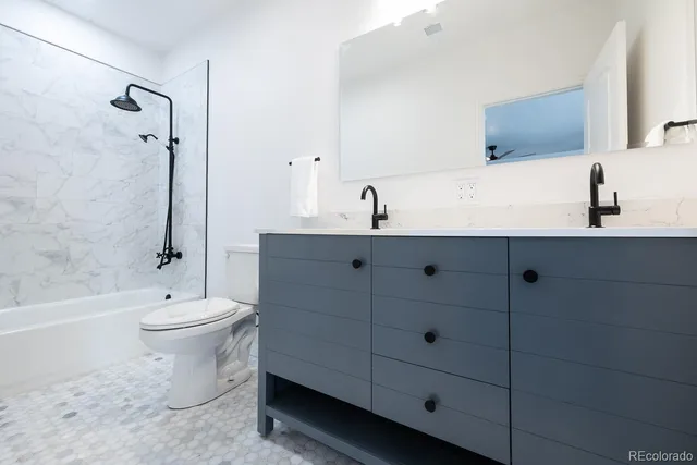 a bathroom with a double vanity sink toilet and shower