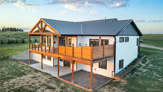 a view of house with a yard and balcony