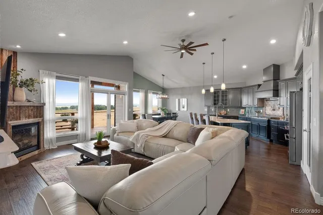 a living room with furniture kitchen view and a fireplace