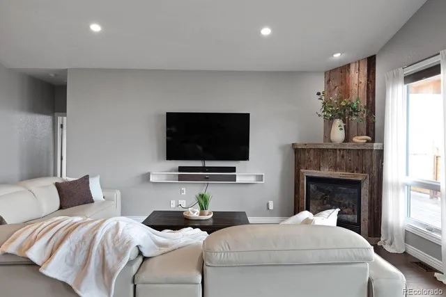 a living room with furniture a flat screen tv and a fireplace