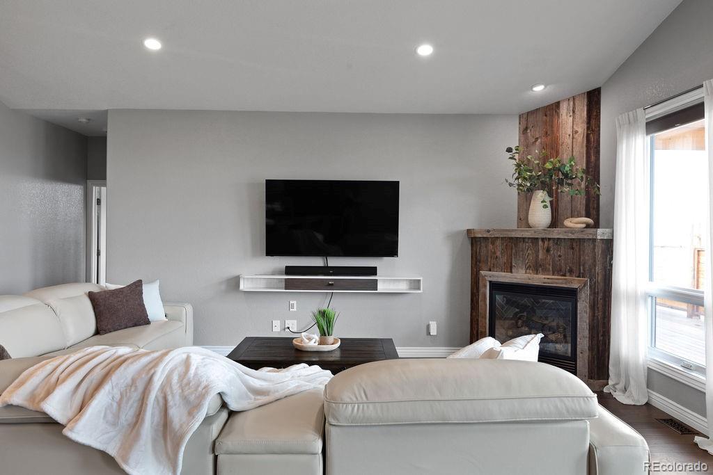 3050 Native Court Wellington, CO 80549 - Photo 9 of 50 a living room with furniture a flat screen tv and a fireplace