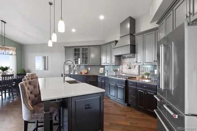 a kitchen with stainless steel appliances granite countertop a sink refrigerator and cabinets