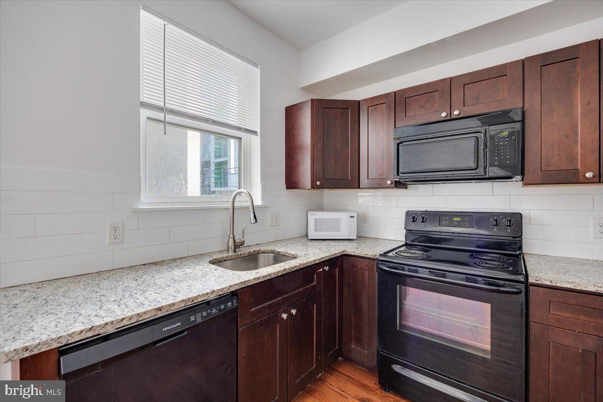 1322 North 15th Street, Unit B Philadelphia, PA 19121 - Photo 2 of 24 a kitchen with granite countertop a sink stove and microwave