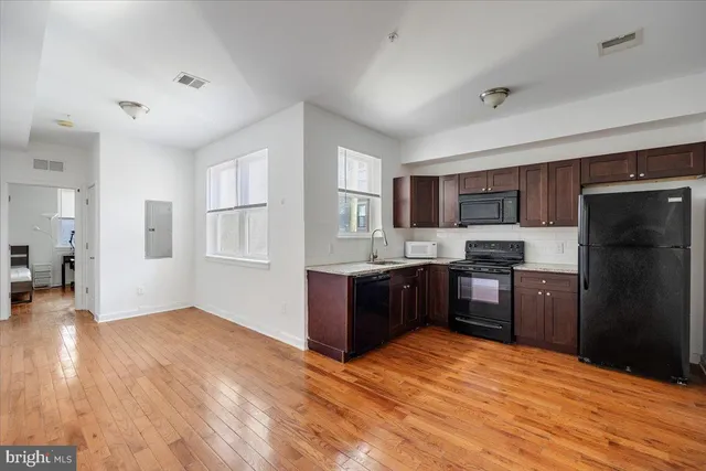a kitchen with granite countertop a refrigerator and wooden cabinets