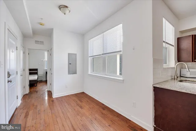 a view of a kitchen from the hallway with a wooden floor