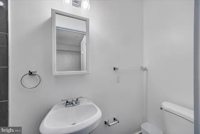 a bathroom with a toilet sink and mirror