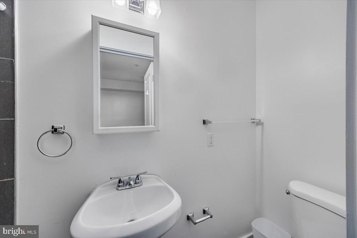 1322 North 15th Street, Unit B Philadelphia, PA 19121 - Photo 9 of 24 a bathroom with a toilet sink and mirror