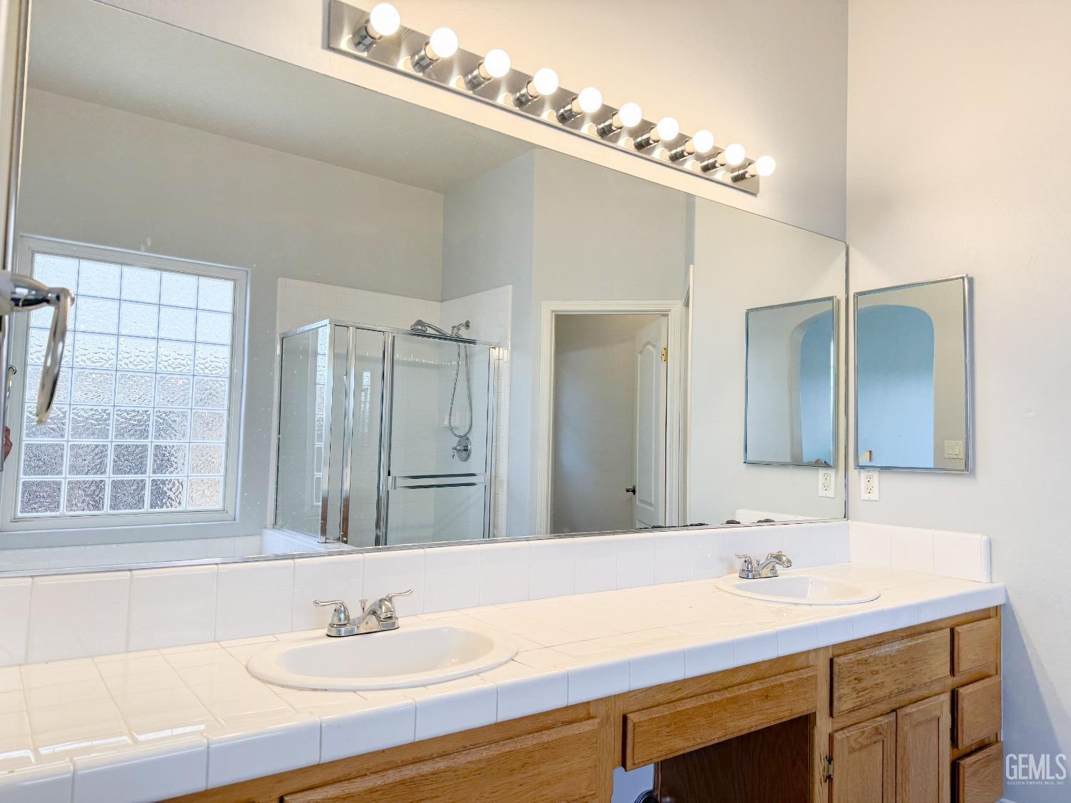 Undisclosed Address Bakersfield, CA 93312 - Photo 14 of 28 a bathroom with a sink double vanity and a mirror