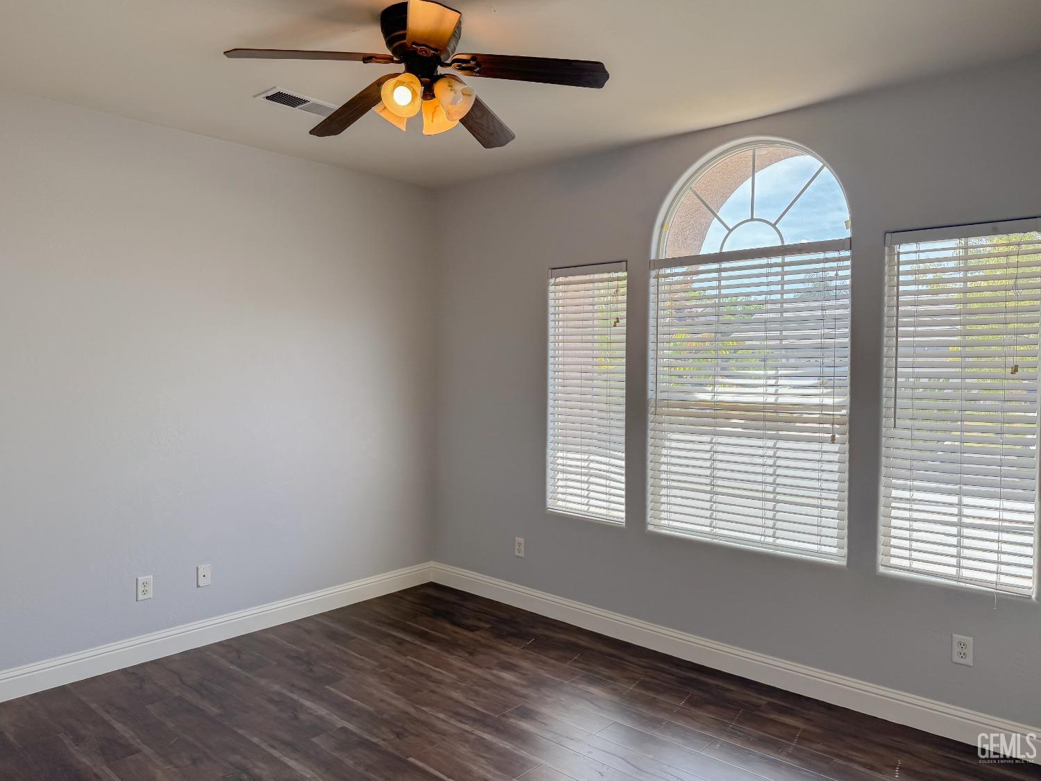 Undisclosed Address Bakersfield, CA 93312 - Photo 24 of 28 an empty room with wooden floor chandelier and windows