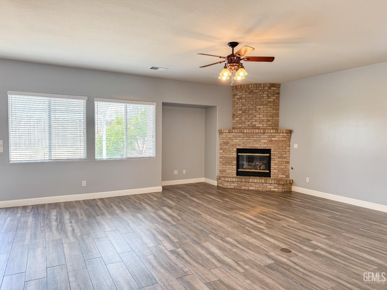 Undisclosed Address Bakersfield, CA 93312 - Photo 5 of 28 a view of an empty room with wooden floor fireplace and a window