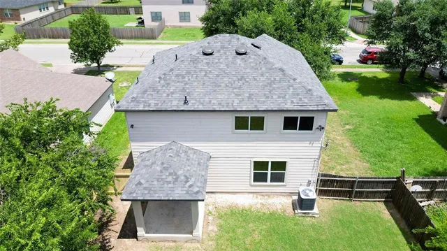 a aerial view of a house with table and chairs next to yard
