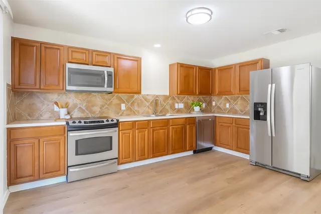 a kitchen with stainless steel appliances granite countertop a refrigerator sink stove and microwave