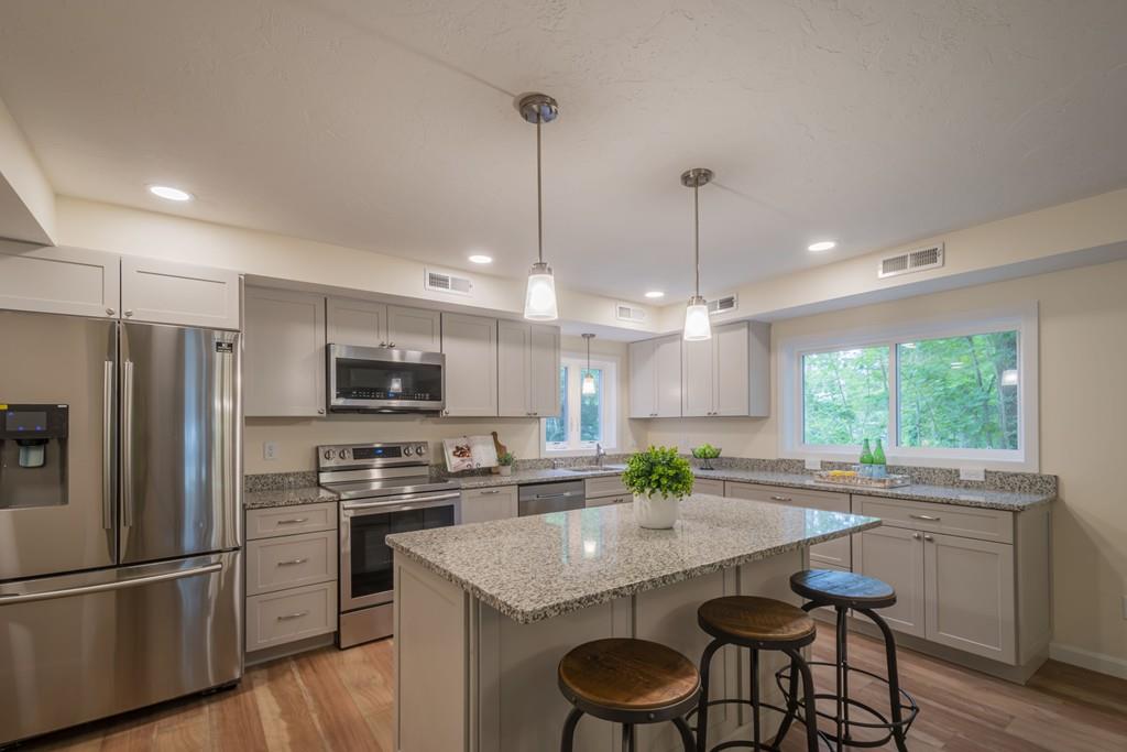 1 Kingman Road Acton, MA 01720 - Photo 15 of 42 a kitchen with kitchen island granite countertop a sink refrigerator and microwave