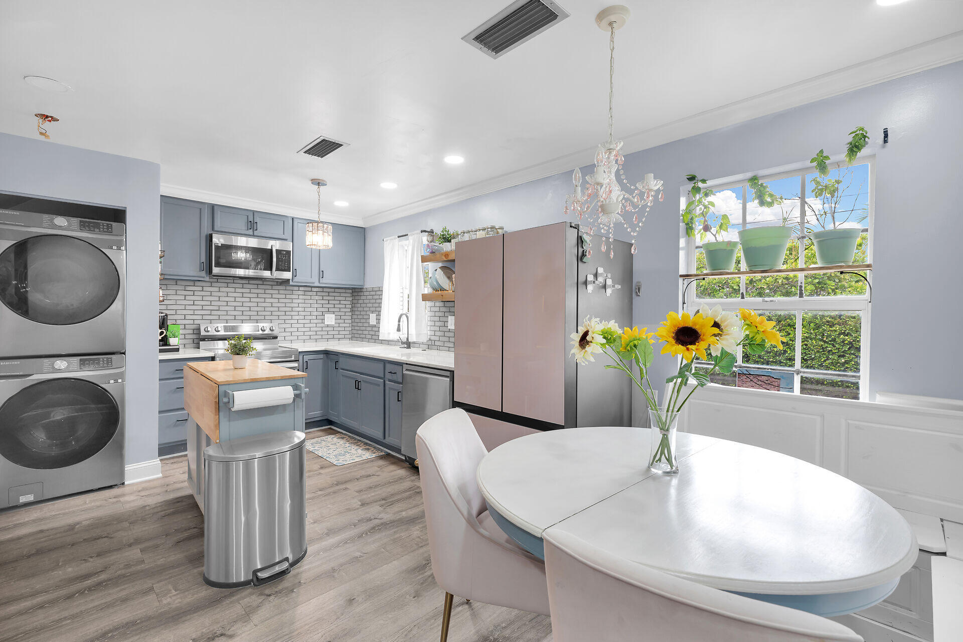 3029 North Roosevelt Boulevard, Unit 54 Key West, FL 33040 - Photo 7 of 31 a kitchen with kitchen island a stove a sink a refrigerator and a dining table with wooden floor