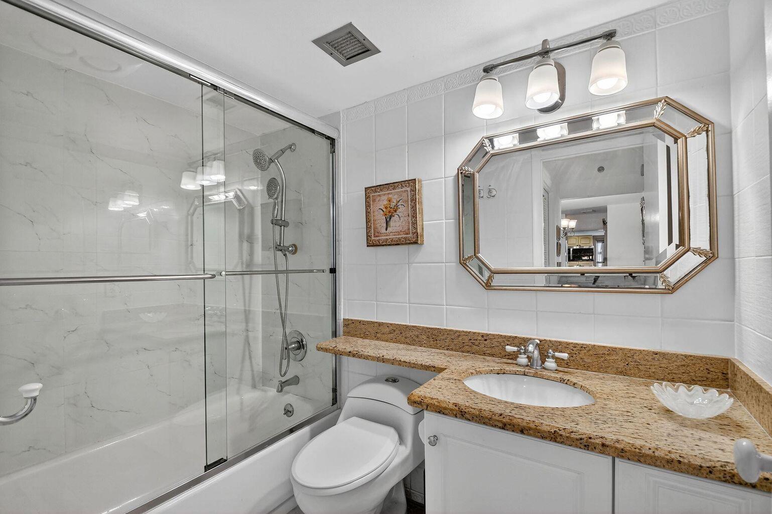 4511 South Ocean Boulevard, Unit 701 Highland Beach, FL 33487 - Photo 7 of 16 a bathroom with a granite countertop sink mirror and a toilet
