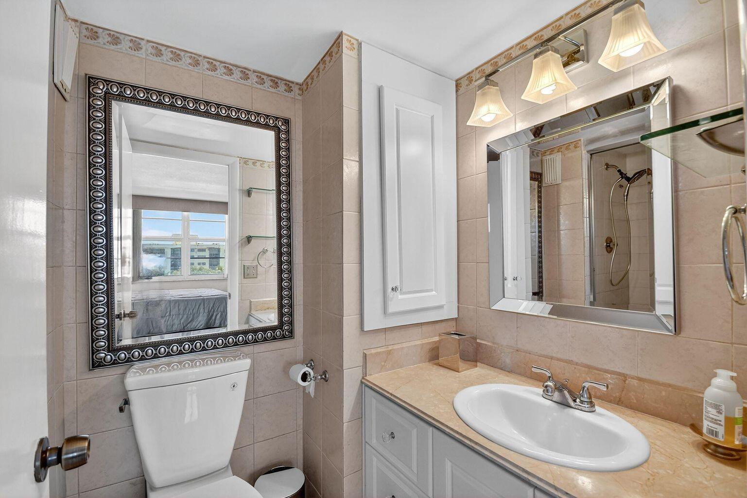 4511 South Ocean Boulevard, Unit 701 Highland Beach, FL 33487 - Photo 9 of 16 a bathroom with a sink vanity granite and a mirror