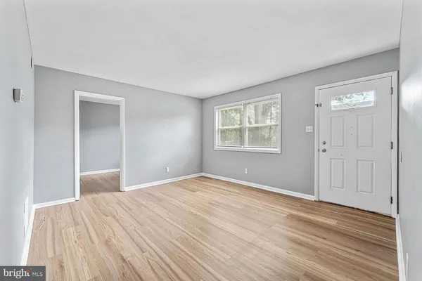 a view of an empty room with wooden floor