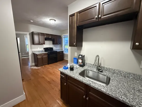 a kitchen with kitchen island granite countertop a sink stainless steel appliances and cabinets