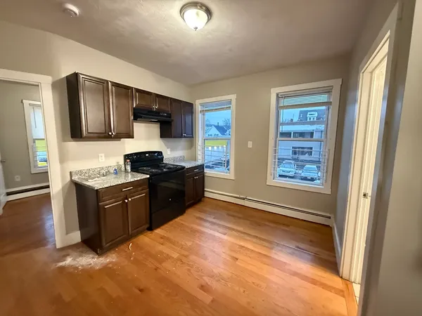 a large kitchen with stainless steel appliances granite countertop a stove a sink and a refrigerator